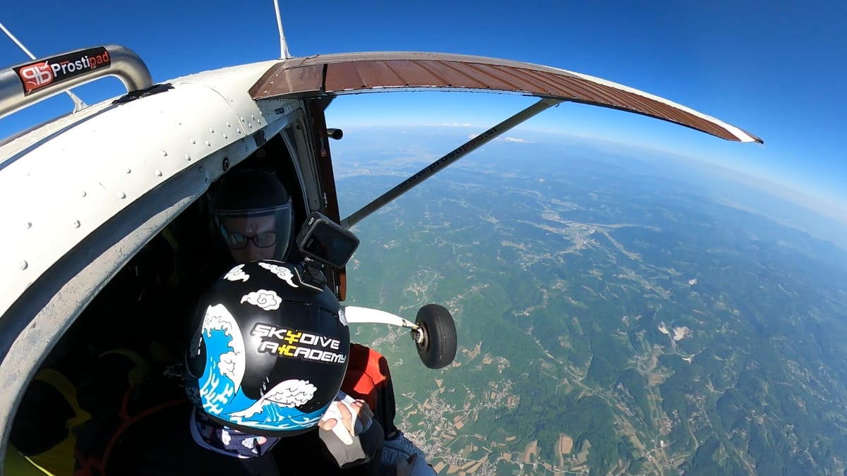Skydiver preparing to exit the plane over Slovenia, wearing a Skydive Academy helmet.