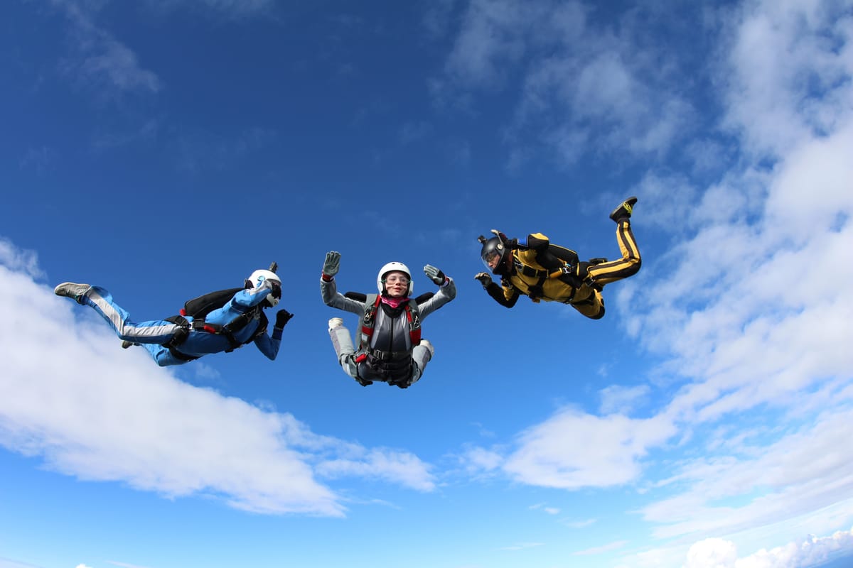 AFF student practicing free fall skills with two instructors on learn to skydive course.