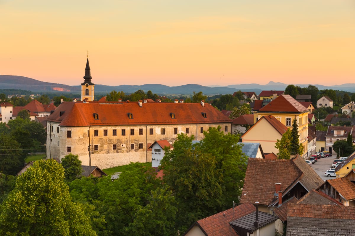 View of Metlika town with historic buildings and surrounding countryside in the Bela krajina region of Slovenia.