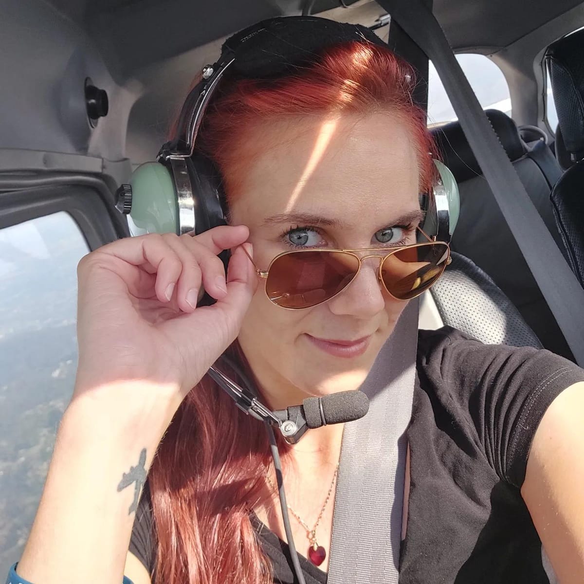 Maja Pađen, skydiver and flight instructor, flying a Cessna 172 with headset and sunglasses.